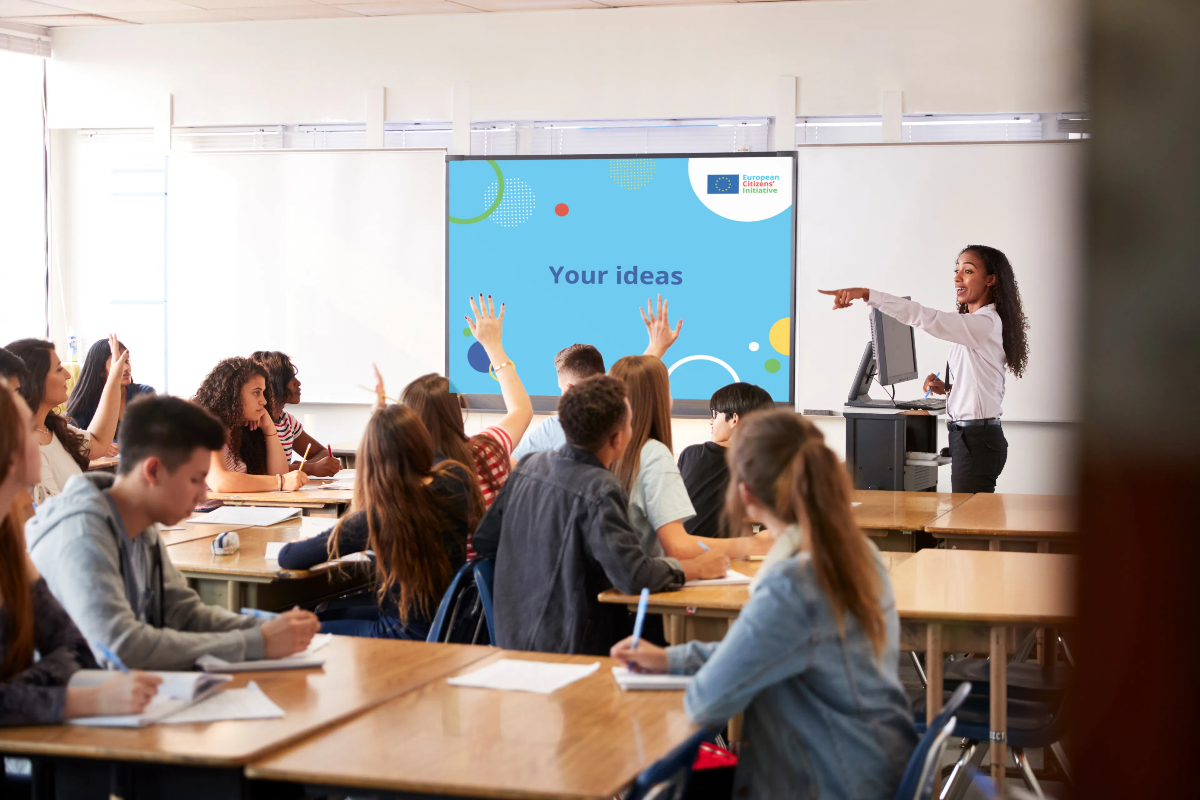 A teacher interacts with a classroom full of students 
