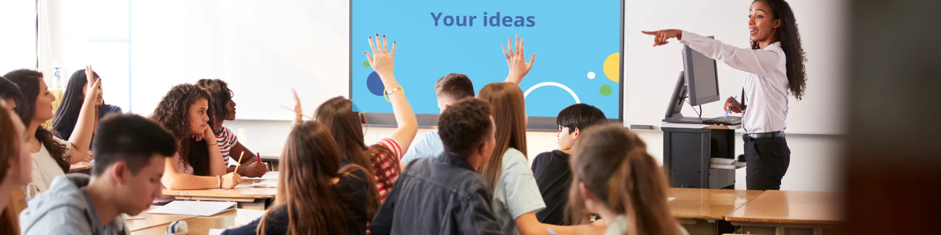 A teacher interacts with a classroom full of students 