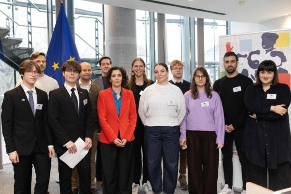 A group of people in front of the EU flag