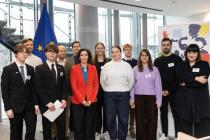 A group of people in front of the EU flag